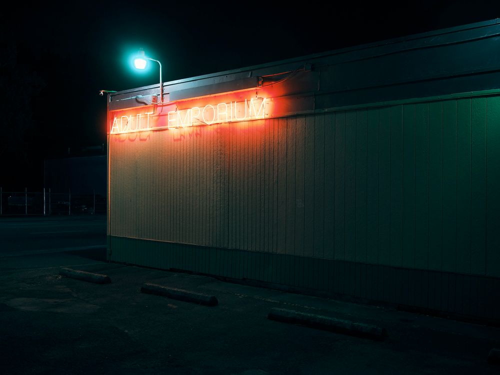 Neon sign reading "adult emporium" at night